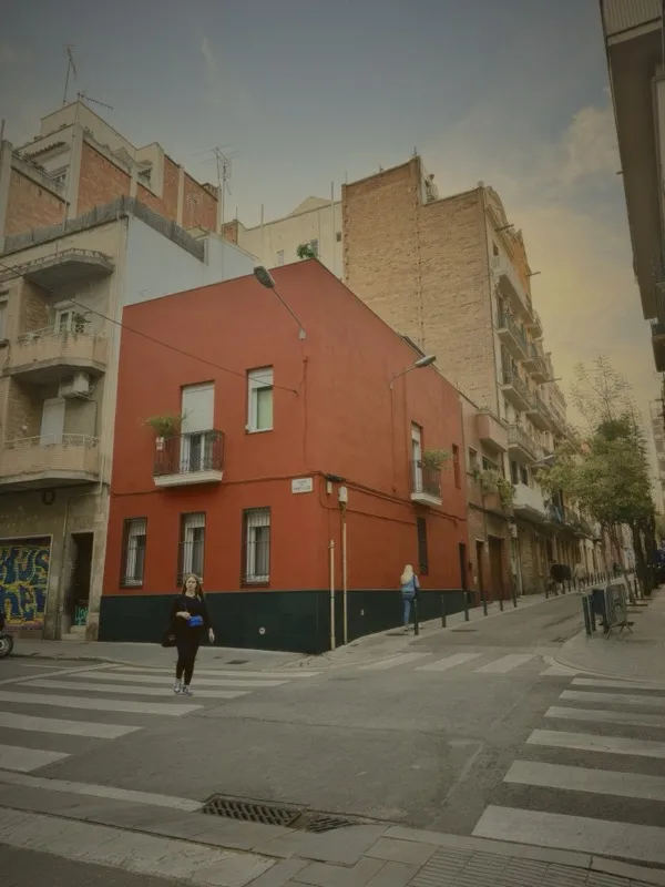 Barcelona street with red building and pedestrian at a crosswalk